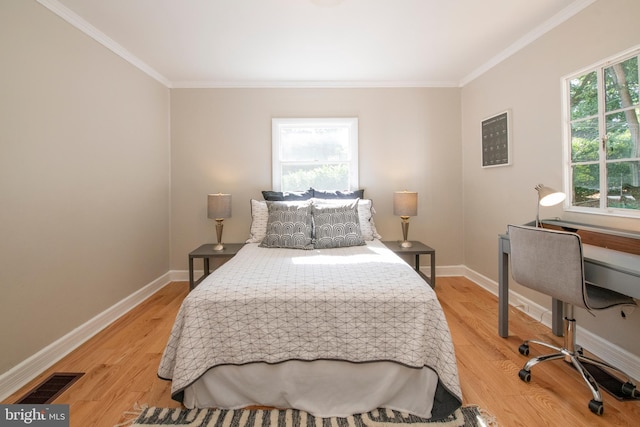 bedroom with light wood-type flooring and crown molding