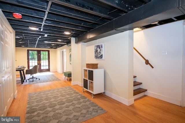 basement featuring french doors and wood-type flooring