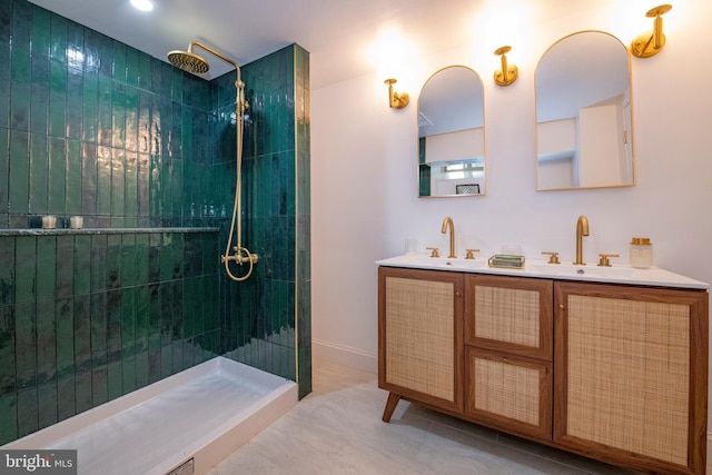 bathroom with tile patterned floors, vanity, and tiled shower