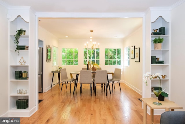 dining room featuring crown molding, light hardwood / wood-style flooring, and an inviting chandelier