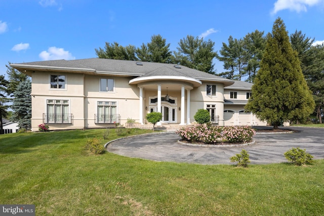 rear view of property featuring a garage and a lawn