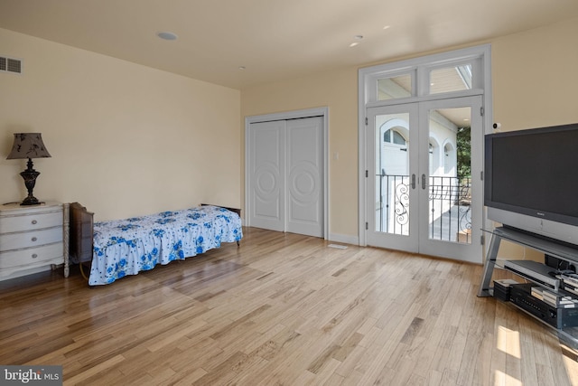 bedroom with access to exterior, french doors, and light hardwood / wood-style floors