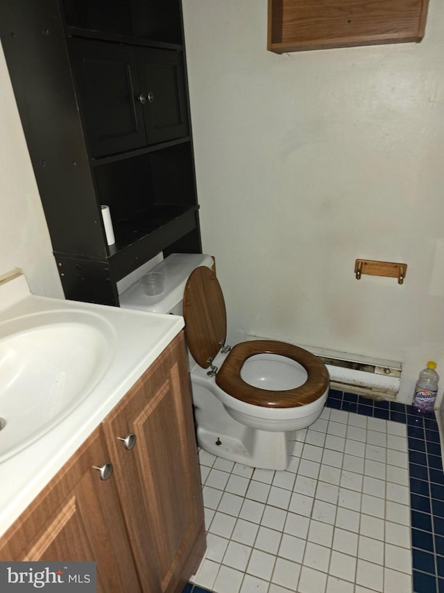 bathroom with tile patterned flooring, vanity, a baseboard heating unit, and toilet