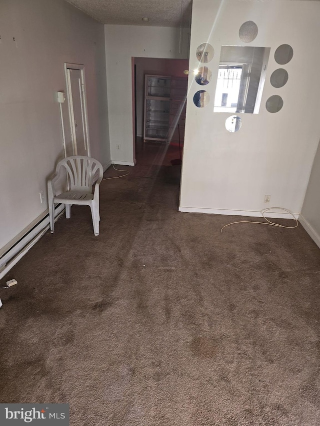 interior space featuring dark carpet and a textured ceiling