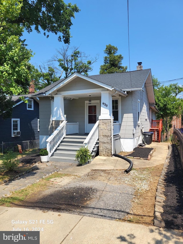 bungalow-style home featuring a porch and cooling unit