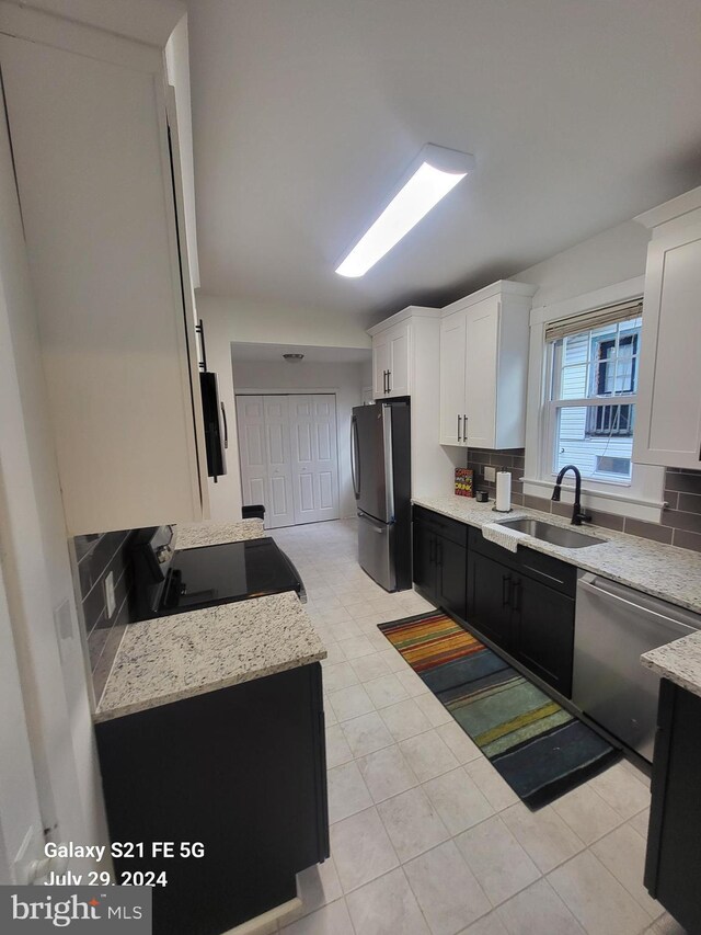 kitchen featuring tasteful backsplash, sink, stainless steel appliances, and white cabinetry