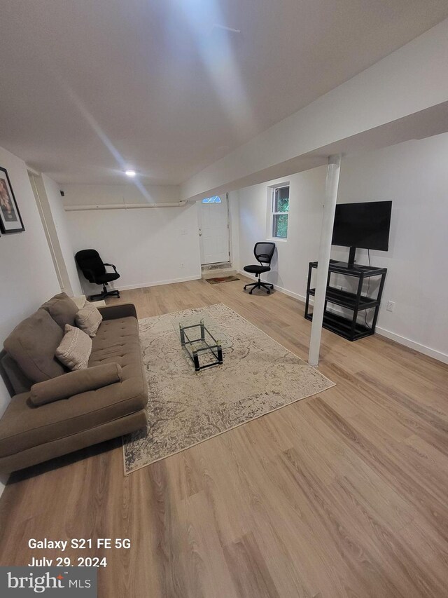 interior space with a baseboard radiator, a healthy amount of sunlight, and wooden walls