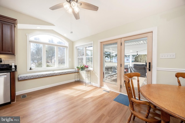 dining room featuring vaulted ceiling, light wood-type flooring, visible vents, and baseboards