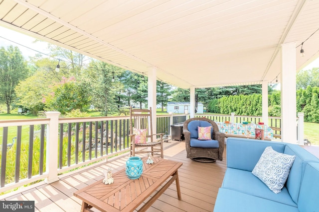 wooden terrace featuring an outdoor living space and an outbuilding