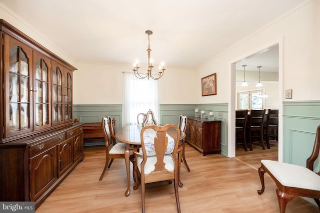 dining room featuring a chandelier, wainscoting, and light wood-style flooring