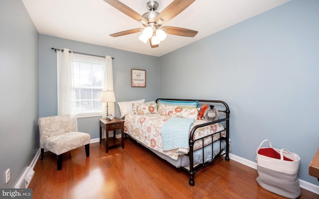 bedroom featuring ceiling fan, baseboards, and wood finished floors