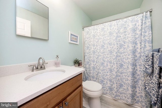 bathroom with a shower with shower curtain, vanity, and toilet