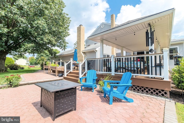 view of patio / terrace featuring a deck and a fire pit