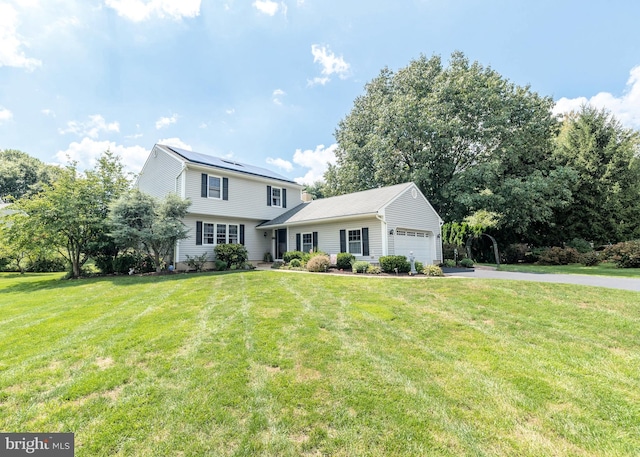 view of front of house with a garage, driveway, and a front lawn