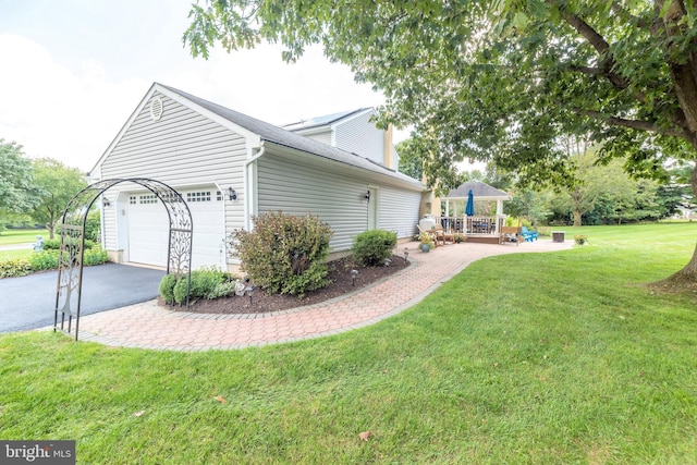 view of home's exterior with a garage, aphalt driveway, and a lawn