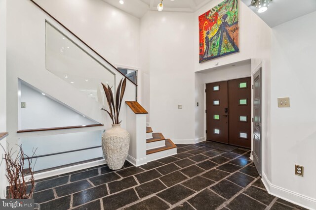 bedroom with dark hardwood / wood-style floors, ensuite bathroom, and a high ceiling