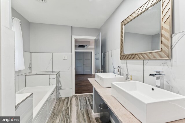 bathroom featuring tile walls, a tile shower, and hardwood / wood-style floors