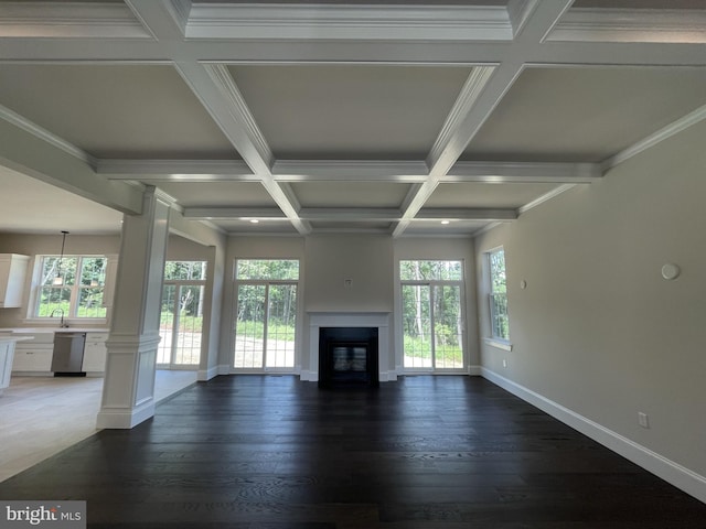 unfurnished living room with coffered ceiling, beamed ceiling, dark wood-type flooring, and a wealth of natural light