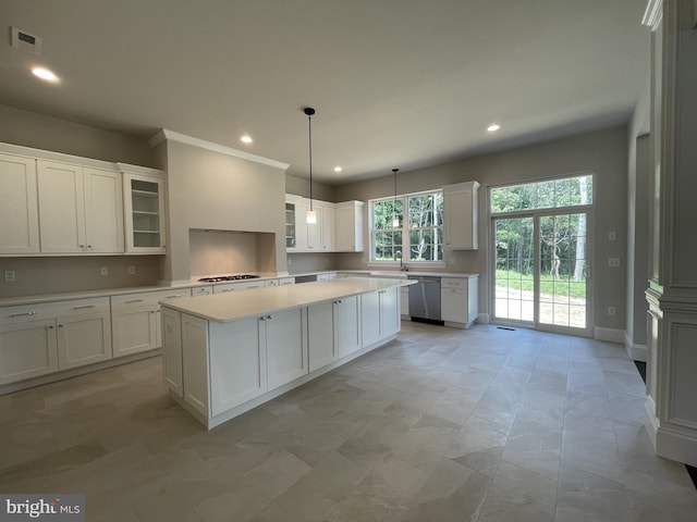 kitchen with pendant lighting, dishwasher, a center island, white cabinetry, and gas stovetop