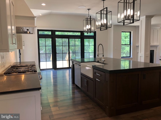 kitchen with a chandelier, dark wood-type flooring, sink, hanging light fixtures, and stainless steel dishwasher