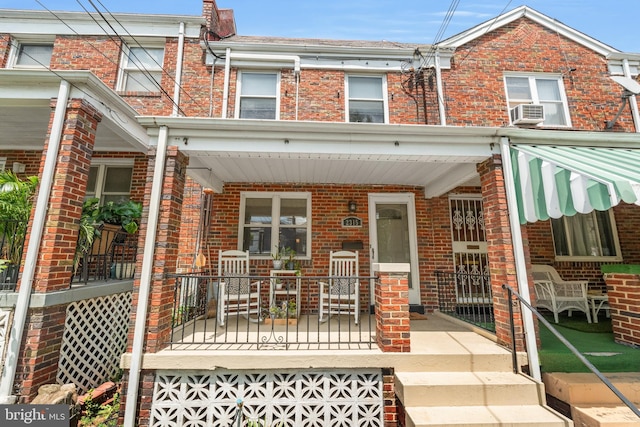 townhome / multi-family property featuring a porch and cooling unit