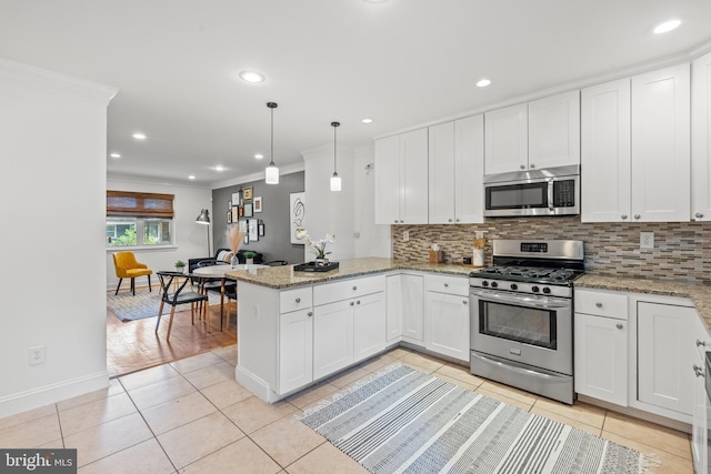 kitchen featuring kitchen peninsula, hanging light fixtures, light tile patterned floors, white cabinetry, and stainless steel appliances