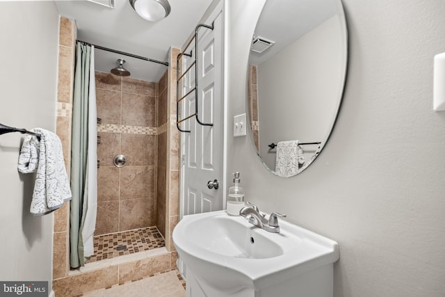 bathroom with a tile shower and sink