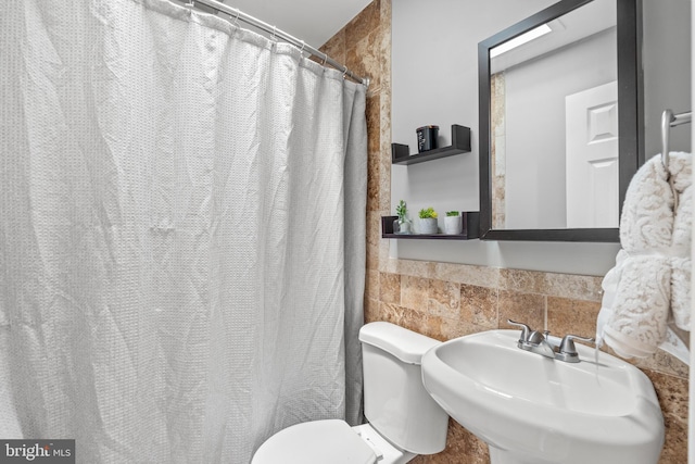 bathroom featuring toilet, sink, and walk in shower