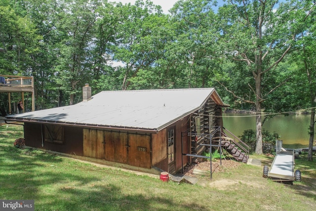 rear view of property with a water view and a yard