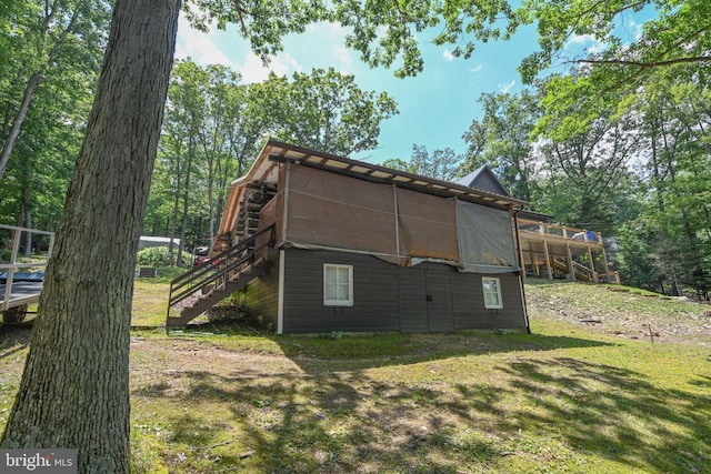 back of house with a wooden deck and a yard