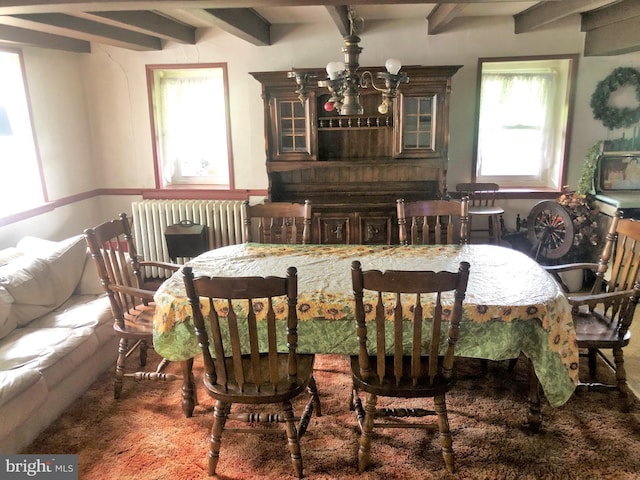 dining area featuring beamed ceiling, a notable chandelier, and radiator