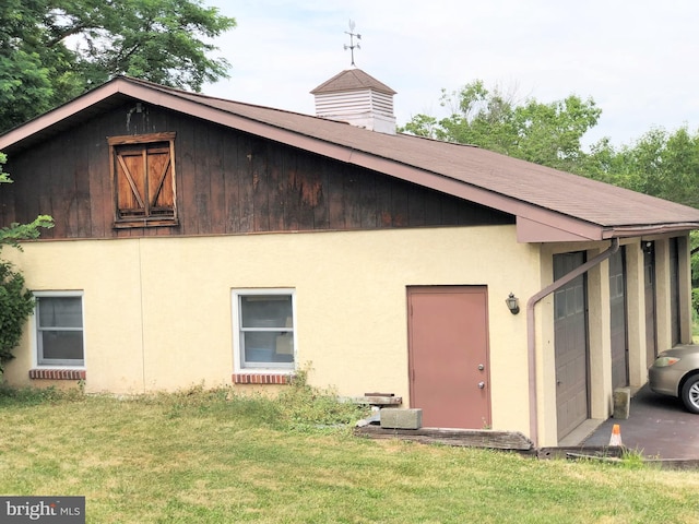 rear view of house with a garage and a yard