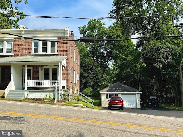 view of front of property with a porch, a garage, and an outdoor structure