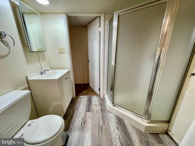 bathroom featuring vanity, hardwood / wood-style flooring, toilet, and an enclosed shower