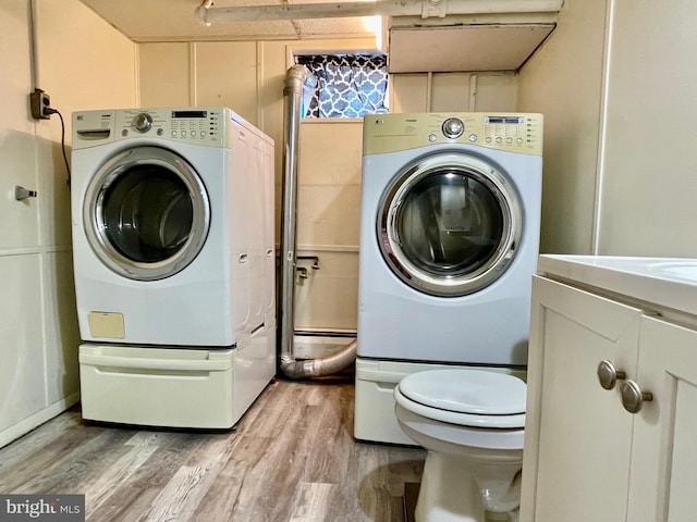 laundry area featuring washing machine and dryer and hardwood / wood-style floors