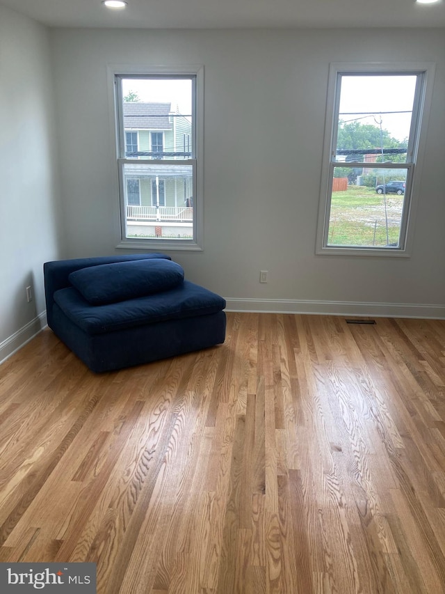 living area featuring a wealth of natural light and light hardwood / wood-style flooring