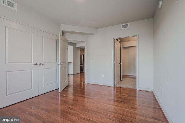 unfurnished bedroom with hardwood / wood-style flooring and a closet