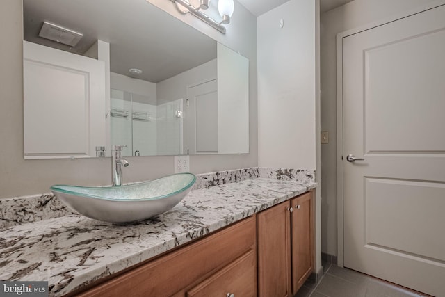 bathroom with tile patterned floors, vanity, and a shower with shower door