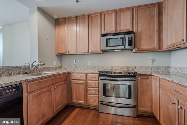 kitchen featuring light stone countertops, sink, dark wood-type flooring, and appliances with stainless steel finishes