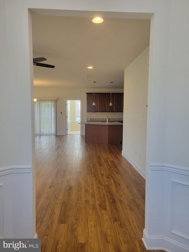 unfurnished living room featuring dark hardwood / wood-style floors and ceiling fan