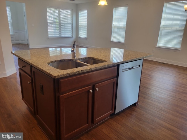 kitchen with dishwasher, an island with sink, sink, dark hardwood / wood-style flooring, and light stone countertops