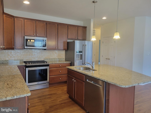 kitchen with sink, decorative backsplash, hanging light fixtures, a kitchen island with sink, and stainless steel appliances