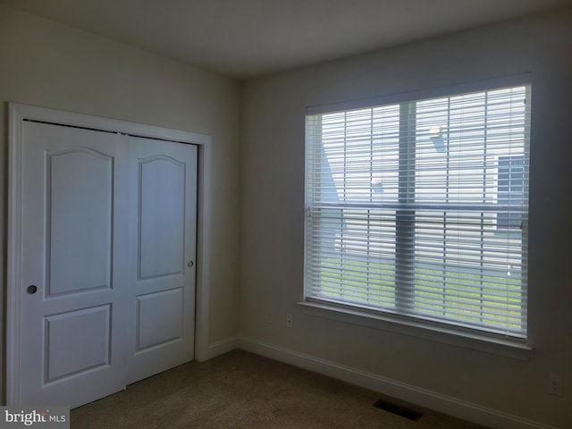 unfurnished bedroom with light carpet and a closet