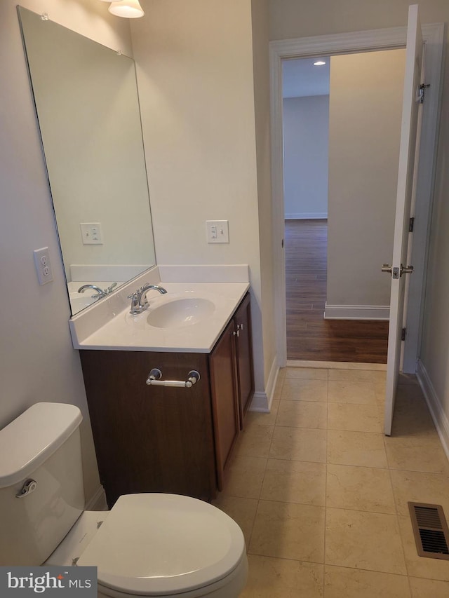 bathroom featuring vanity, tile patterned floors, and toilet