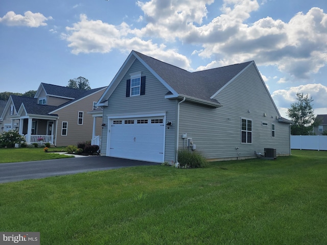 view of side of home with cooling unit, a garage, and a lawn