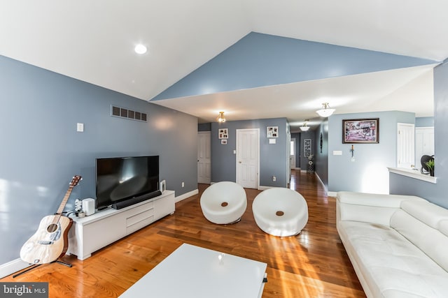 living room with wood-type flooring and high vaulted ceiling