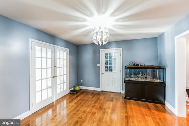 doorway to outside featuring a chandelier, french doors, wood-type flooring, and a wealth of natural light