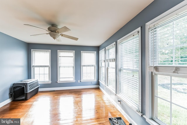 unfurnished sunroom with a wealth of natural light and ceiling fan