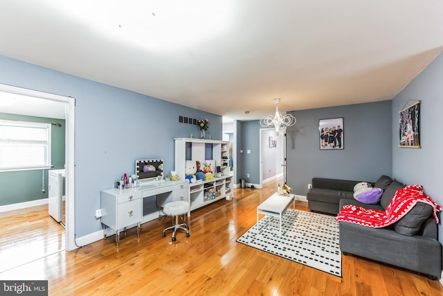 living room featuring a notable chandelier and light wood-type flooring