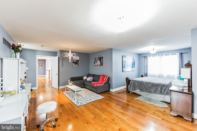 bedroom featuring a notable chandelier and light wood-type flooring